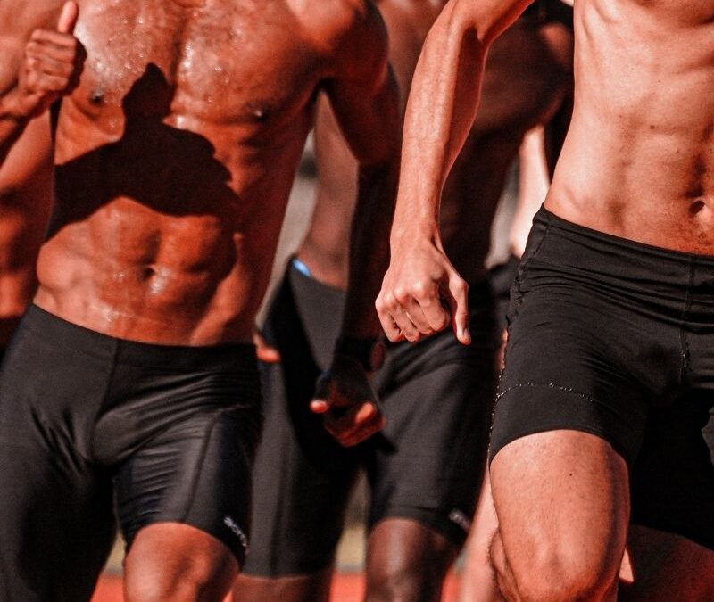 Black men in shorts running with no shirts
